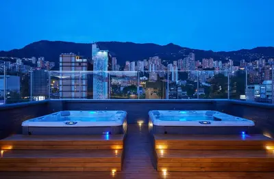 two tubs on a balcony with a view of a city at Hotel Selis in Medellín