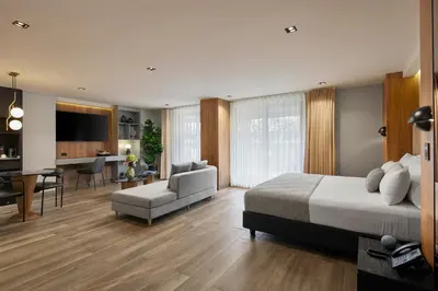 a bedroom with a large bed and a living room at Hotel Selis in Medellín