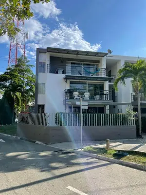 a white building with a fence in front of it at Apartasol privado Santa Fe de Antioquia in Santa Fe de Antioquia