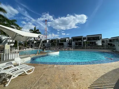 a swimming pool with two lounge chairs in front of a building at Apartasol privado Santa Fe de Antioquia in Santa Fe de Antioquia