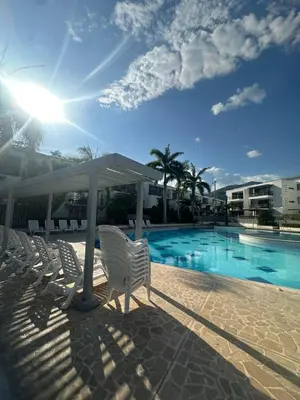 a group of white chairs next to a swimming pool at Apartasol privado Santa Fe de Antioquia in Santa Fe de Antioquia