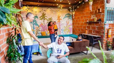 a group of people standing around a man shaking hands at Spring Hostel in Medellín
