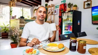 a man sitting at a table with a plate of food at Spring Hostel in Medellín