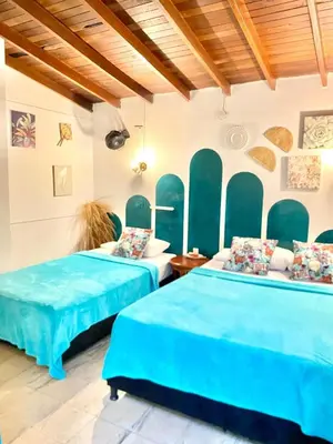 two beds with blue sheets in a room at Spring Hostel in Medellín