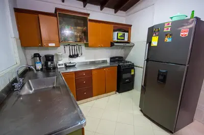 a kitchen with a stainless steel refrigerator and wooden cabinets at Spring Hostel in Medellín