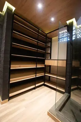 a walk in closet with black shelves and a glass door at Deluxe Man cave with jacuzzy in Envigado
