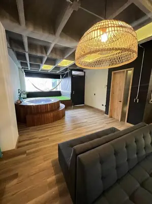 a living room with a couch and a bed at Deluxe Man cave with jacuzzy in Envigado