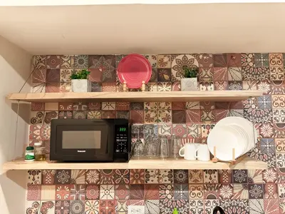 a kitchen with a microwave and plates on a wall at Arrendamiento nuevo apartamento con balcón By Roots Rentals NID202 in Medellín