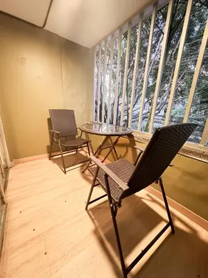 a balcony with two chairs and a table and a window at Arrendamiento nuevo apartamento con balcón By Roots Rentals NID202 in Medellín