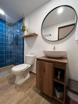 a bathroom with a toilet and a sink and a mirror at Nuevo estudio cerca de Plaza Mayor NID101 By Roots Rentals in Medellín