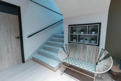a room with a staircase and a chair and a stair case at Nuevo estudio cerca de Plaza Mayor NID101 By Roots Rentals in Medellín