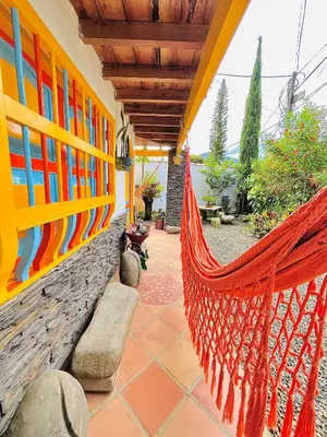 a hammock on the side of a house at Casa de las Rocas Hostel in Jardin