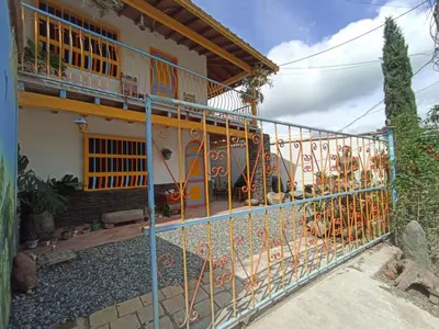 a house with a gate in front of it at Casa de las Rocas Hostel in Jardin