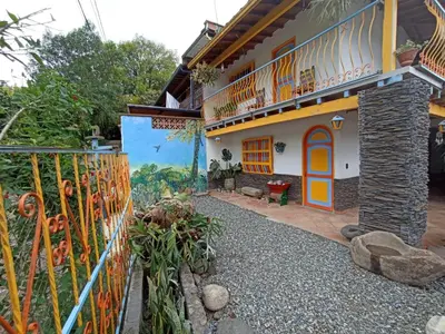 a house with a painting on the side of it at Casa de las Rocas Hostel in Jardin