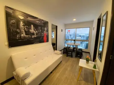 a living room with a white couch and a table at Torres de San Vicente 2 hab in Manizales