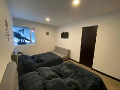 a bedroom with two beds and a television in it at Torres de San Vicente 2 hab in Manizales