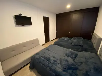 a bedroom with two beds and a flat screen tv at Torres de San Vicente 2 hab in Manizales