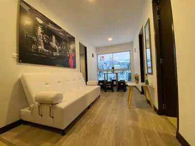 a living room with a white couch and a window at Torres de San Vicente 2 hab in Manizales