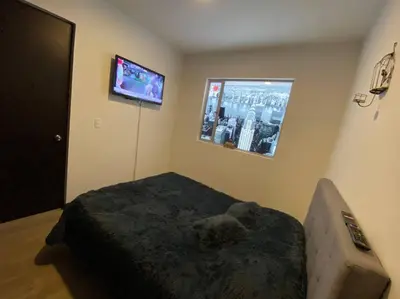 a bedroom with a bed and a tv on the wall at Torres de San Vicente 2 hab in Manizales