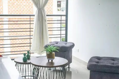 a living room with a blue chair and a table at Apartamento en zona exclusiva de Bello, Cabañas in Bello