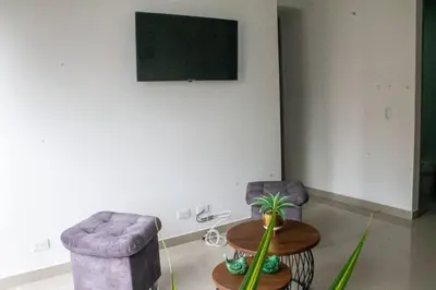 a living room with two chairs and a table and a tv at Apartamento en zona exclusiva de Bello, Cabañas in Bello