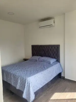 a bedroom with a bed with a blue comforter at Cabaña en Sopetran in Sopetran