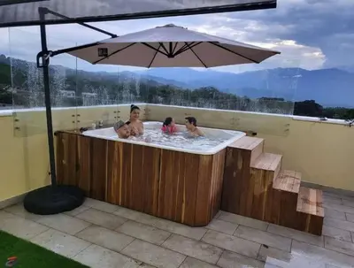 a group of people in a hot tub with an umbrella at Cabaña en Sopetran in Sopetran