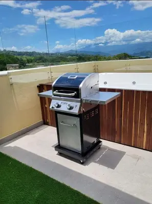 a grill sitting on top of a patio with grass at Cabaña en Sopetran in Sopetran