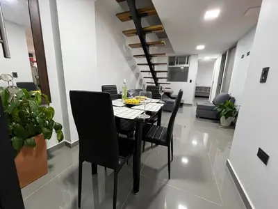 a dining room with a black table and chairs at nuevo amanecer in Bello