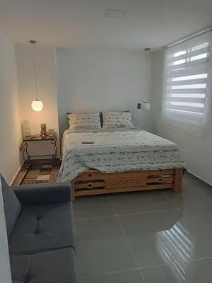 a bedroom with a large bed and a chair at nuevo amanecer in Bello
