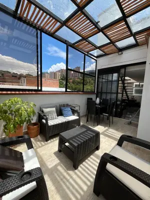 a screened in patio with a couch and a table at nuevo amanecer in Bello