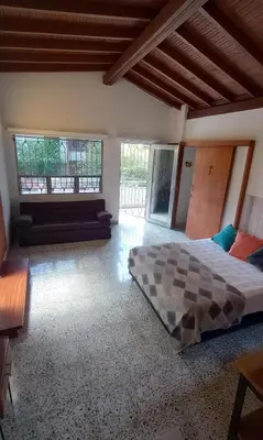 a bedroom with a bed and a couch and windows at CASA DE LOLA in Medellín