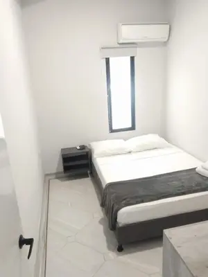 a white bedroom with a bed and a window at Hotel la Carpita in El Poblado
