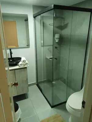 a bathroom with a glass shower with a toilet at Hotel la Carpita in El Poblado