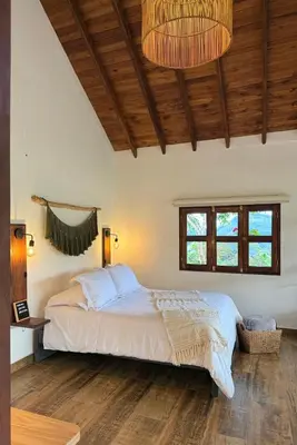 a bedroom with a bed and a wooden ceiling at Cabañas Sentido Ancestral in Jardin