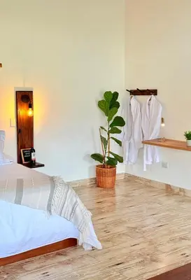 a bedroom with a bed and a potted plant at Cabañas Sentido Ancestral in Jardin