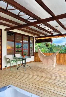 a patio with a hammock and a table and chairs at Cabañas Sentido Ancestral in Jardin