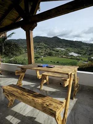 a wooden picnic table on a porch with a view at Finca Completa Carmen Viboral Naturaleza y Privacidad in Carmen de Viboral