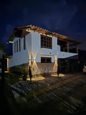 a white house with lights in front of it at night at Finca Completa Carmen Viboral Naturaleza y Privacidad in Carmen de Viboral