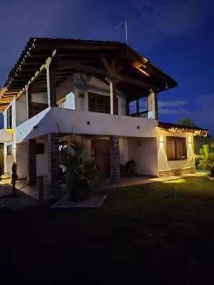 a house with a lit up facade at night at Finca Completa Carmen Viboral Naturaleza y Privacidad in Carmen de Viboral