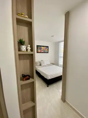 a bedroom with a bed in a room with shelves at Acogedor Apartamento Como en casa in Manizales