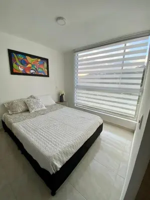 a bedroom with a bed and a large window at Acogedor Apartamento Como en casa in Manizales