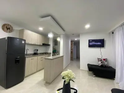 a kitchen with a black refrigerator in a room at Acogedor Apartamento Como en casa in Manizales