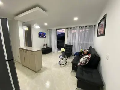 a person laying on a couch in a living room at Acogedor Apartamento Como en casa in Manizales