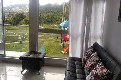 a living room with a couch and a large window at Acogedor Apartamento Como en casa in Manizales
