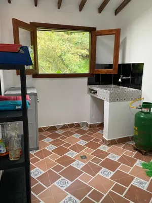 a kitchen with a tiled floor and a window at River house in Jardin