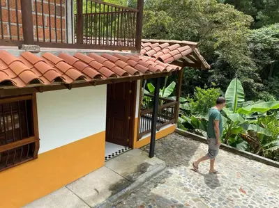 a man walking in front of a building at River house in Jardin