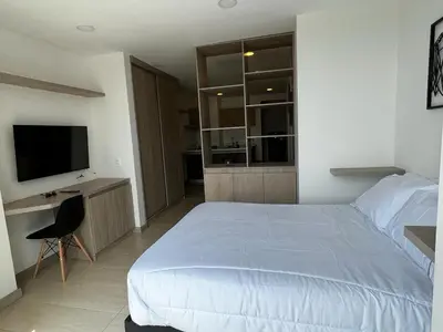 a bedroom with a bed and a desk and a television at Apartamento de lujo Manizales in Manizales