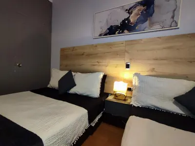 a bedroom with two beds and a table with a lamp at Libertador in Medellín