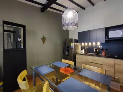 a dining room with a glass table and a kitchen at Libertador in Medellín